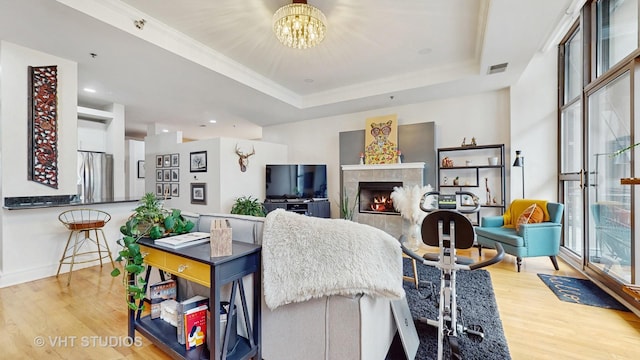 212 W Washington St Unit 1108, Chicago, IL 60606 - living room with wood finished floors, a tray ceiling, a chandelier, a tile fireplace, and recessed lighting