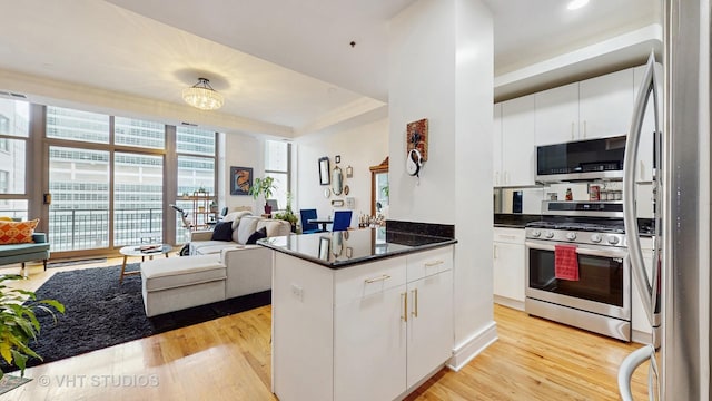 212 W Washington St Unit 1108, Chicago, IL 60606 - kitchen with appliances with stainless steel finishes, light wood finished floors, white cabinetry, open floor plan, and a peninsula