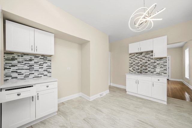 7421 S Eggleston Ave, Chicago, IL 60621 - kitchen with tasteful backsplash, a chandelier, white cabinetry, light countertops, and baseboards
