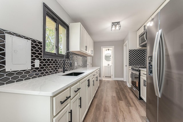 16632 Sawyer Ave, Markham, IL 60428 - kitchen with stainless steel appliances, decorative backsplash, light wood-style flooring, and white cabinets