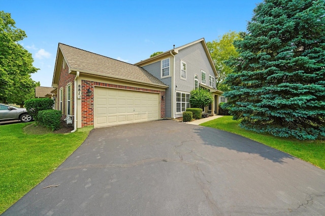 881 Dandridge Ct, Elgin, IL 60120 - view of front of home featuring brick siding, an attached garage, driveway, and a front lawn