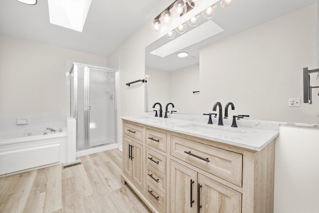 881 Dandridge Ct, Elgin, IL 60120 - bathroom with a skylight, a shower stall, a bath, double vanity, and wood finished floors