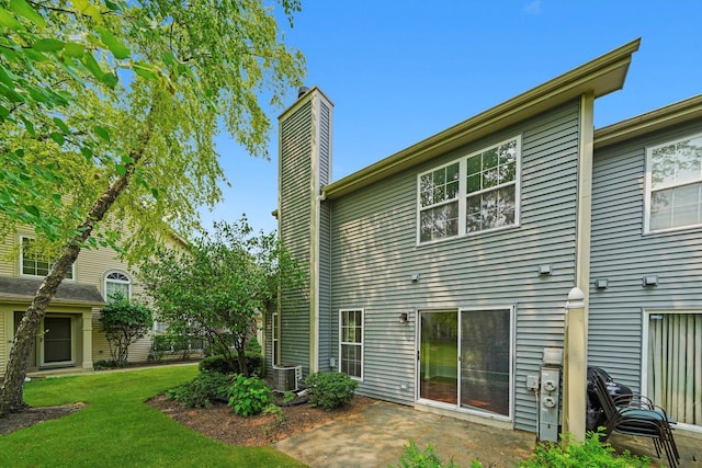 881 Dandridge Ct, Elgin, IL 60120 - rear view of property featuring a chimney, a lawn, and a patio area