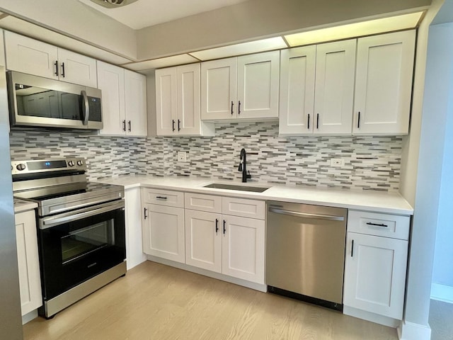 4125 N Keystone Ave Unit 605, Chicago, IL 60641 - kitchen with appliances with stainless steel finishes, light wood finished floors, light countertops, white cabinets, and tasteful backsplash