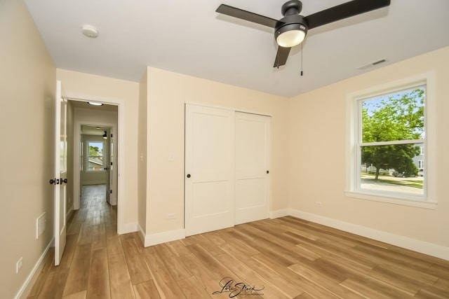 223 E 20th Ct, Lockport, IL 60441 - unfurnished bedroom featuring light wood finished floors, multiple windows, a closet, and a ceiling fan