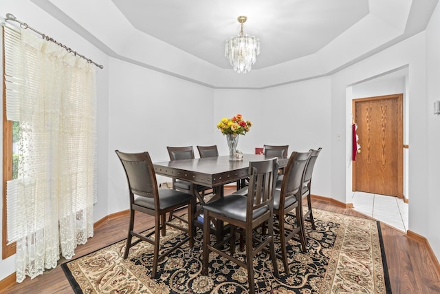 7008 Plymouth Ct Unit 7008, Tinley Park, IL 60477 - dining space featuring a chandelier, a tray ceiling, and wood finished floors