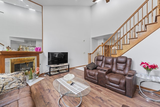 7008 Plymouth Ct Unit 7008, Tinley Park, IL 60477 - living area featuring a high ceiling, stairway, wood finished floors, a ceiling fan, and a fireplace with flush hearth