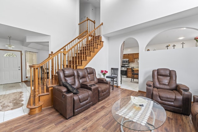 7008 Plymouth Ct Unit 7008, Tinley Park, IL 60477 - living area with arched walkways, a high ceiling, light wood-style floors, and stairs