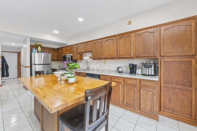 7008 Plymouth Ct Unit 7008, Tinley Park, IL 60477 - kitchen with appliances with stainless steel finishes, light tile patterned flooring, backsplash, brown cabinets, and wooden counters
