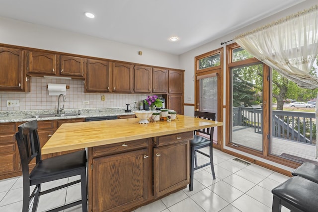7008 Plymouth Ct Unit 7008, Tinley Park, IL 60477 - kitchen featuring butcher block countertops, a kitchen breakfast bar, tasteful backsplash, light tile patterned flooring, and recessed lighting