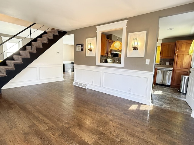 21317 W Shady Ln, Lake Zurich, IL 60047 - unfurnished living room featuring stairs, dark wood-style flooring, a decorative wall, and wainscoting