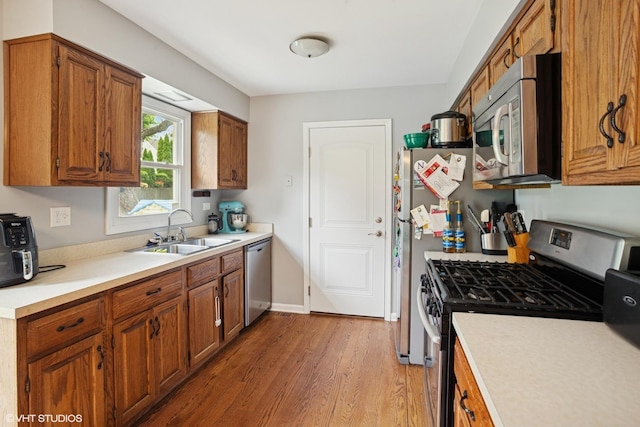 525 Andrew Ln, Lake Zurich, IL 60047 - kitchen featuring stainless steel appliances, a sink, light wood-style flooring, brown cabinets, and light countertops