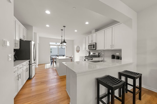 29W711 Cambridge St, Warrenville, IL 60555 - kitchen with appliances with stainless steel finishes, decorative backsplash, recessed lighting, a peninsula, and white cabinetry