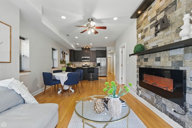 4857 N Drake Ave Unit G, Chicago, IL 60625 - living area featuring light wood-type flooring, a stone fireplace, a ceiling fan, and recessed lighting