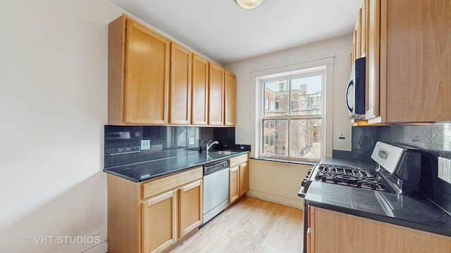 1646 E 54th St Unit 2, Chicago, IL 60615 - kitchen with stainless steel appliances, light wood-type flooring, tasteful backsplash, and dark countertops