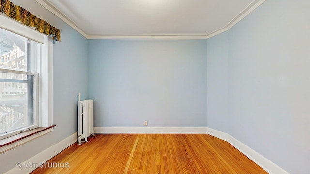 1646 E 54th St Unit 2, Chicago, IL 60615 - spare room featuring radiator heating unit, healthy amount of natural light, light wood-style floors, and crown molding