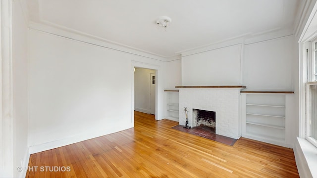 1646 E 54th St Unit 2, Chicago, IL 60615 - unfurnished living room featuring light wood finished floors, a brick fireplace, ornamental molding, and built in features