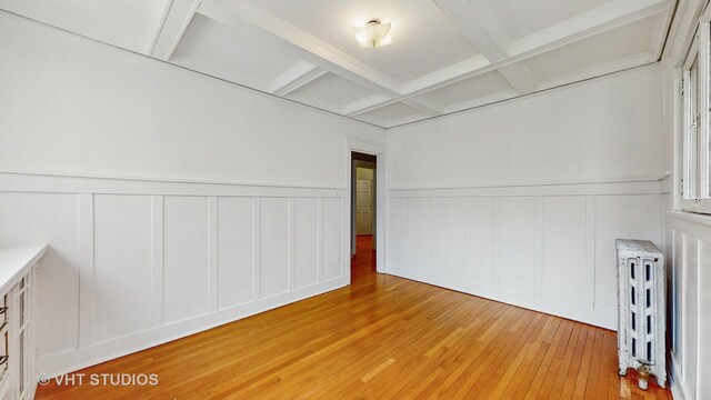 1646 E 54th St Unit 2, Chicago, IL 60615 - unfurnished room with radiator heating unit, light wood-style floors, coffered ceiling, a decorative wall, and beamed ceiling