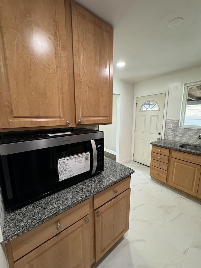 8117 S Keating Ave, Chicago, IL 60652 - kitchen featuring a sink, dark stone counters, baseboards, light marble finish floors, and tasteful backsplash