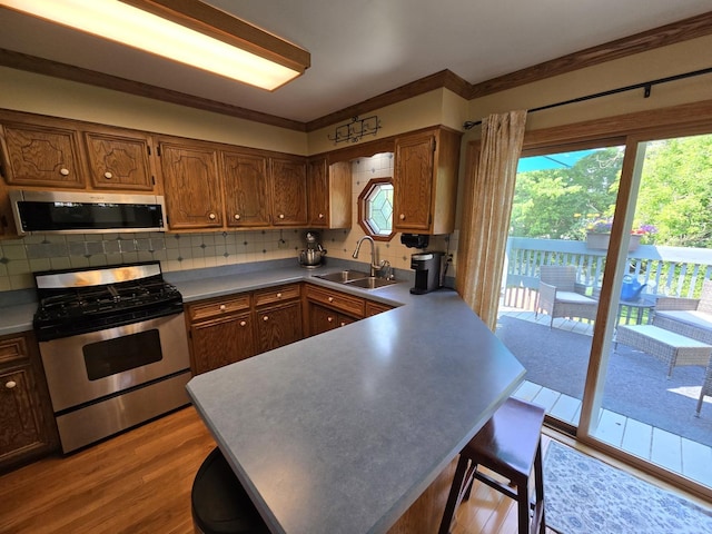 4910 143rd Pl, Midlothian, IL 60445 - kitchen with appliances with stainless steel finishes, a sink, a peninsula, and healthy amount of natural light