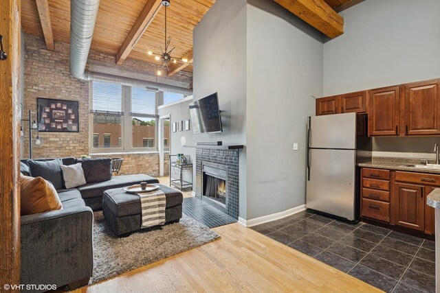 2510 N Wayne Ave Unit 302, Chicago, IL 60614 - living area featuring a towering ceiling, wood ceiling with exposed beams, a fireplace, brick wall, and a chandelier