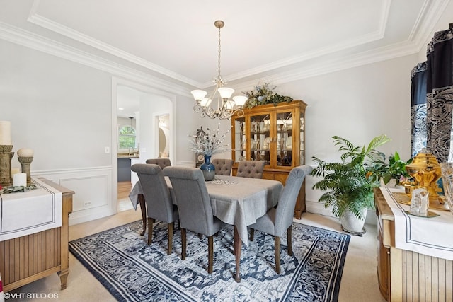 13008 Rockfish Ln, Plainfield, IL 60585 - dining area featuring a chandelier, crown molding, light carpet, a raised ceiling, and wainscoting