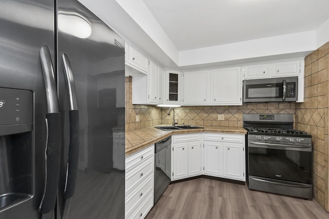7200 N Ridge Blvd Unit 2K, Chicago, IL 60645 - kitchen featuring stainless steel appliances, tile countertops, white cabinets, and dark wood-style flooring