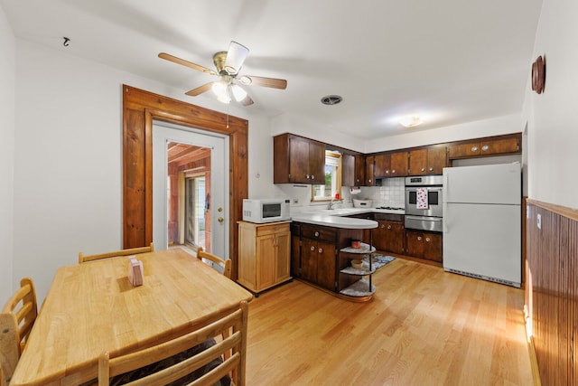 436 Marion St, Bensenville, IL 60106 - kitchen featuring white appliances, a peninsula, light countertops, light wood finished floors, and ceiling fan