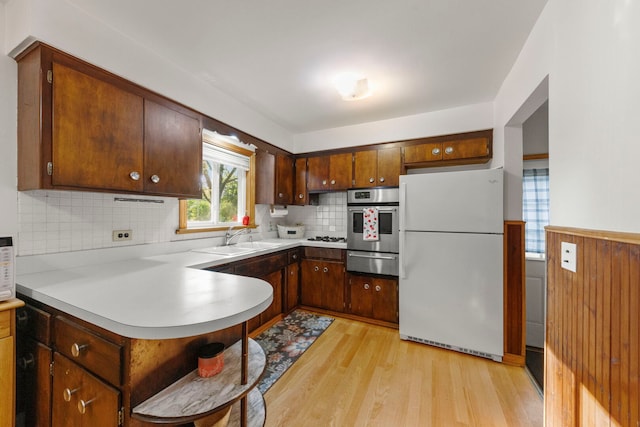 436 Marion St, Bensenville, IL 60106 - kitchen with freestanding refrigerator, stainless steel oven, a warming drawer, light wood-type flooring, and a peninsula