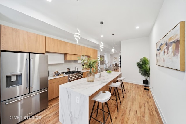 4752 S Champlain Ave, Chicago, IL 60615 - kitchen with appliances with stainless steel finishes, a kitchen bar, light wood-type flooring, a center island, and recessed lighting