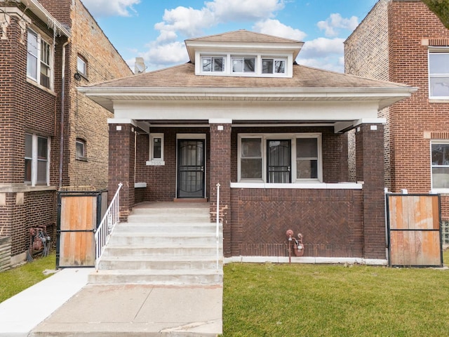7955 S May St, Chicago, IL 60620 - view of front of house with brick siding, a porch, a front yard, and roof with shingles