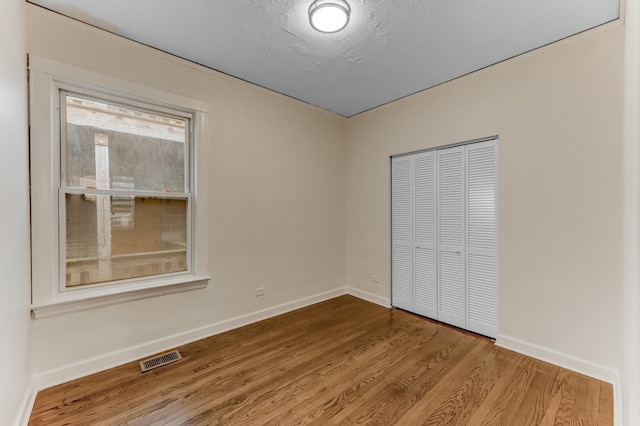 7955 S May St, Chicago, IL 60620 - unfurnished bedroom featuring wood finished floors, a closet, and baseboards