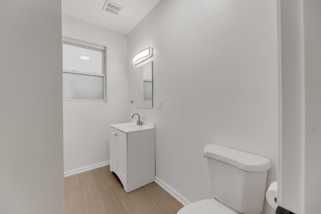 7955 S May St, Chicago, IL 60620 - half bath featuring toilet, vanity, baseboards, and wood finished floors