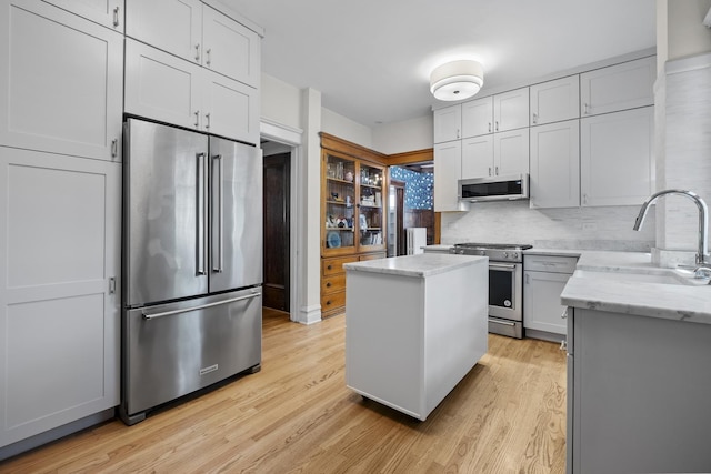 1419 W Birchwood Ave, Chicago, IL 60626 - kitchen featuring stainless steel appliances, light wood-style flooring, a kitchen island, and light stone countertops