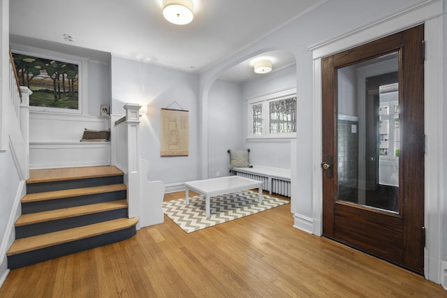 1419 W Birchwood Ave, Chicago, IL 60626 - entrance foyer featuring wood finished floors, arched walkways, stairway, radiator heating unit, and crown molding