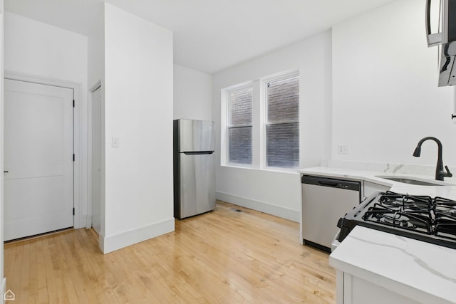 1928 W 21st St, Chicago, IL 60608 - kitchen featuring appliances with stainless steel finishes, light wood-style flooring, and light stone countertops