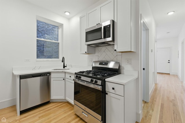 1928 W 21st St, Chicago, IL 60608 - kitchen with appliances with stainless steel finishes, light wood-style floors, backsplash, and light countertops