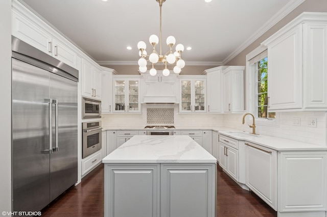 1219 Parkside Ln, Deerfield, IL 60015 - kitchen featuring built in appliances, custom range hood, white cabinets, a kitchen island, and crown molding