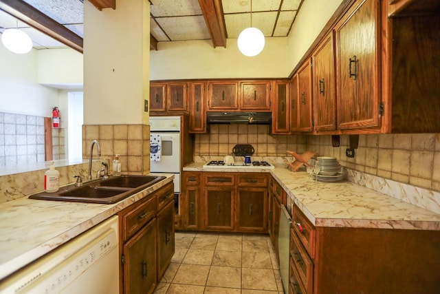 5502 S Hyde Park Blvd Unit 1, Chicago, IL 60637 - kitchen featuring white appliances, a sink, under cabinet range hood, backsplash, and light countertops