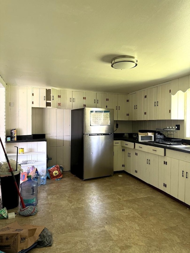 26048 S Dixie Hwy, Crete, IL 60417 - kitchen with freestanding refrigerator, dark countertops, white microwave, and white cabinetry