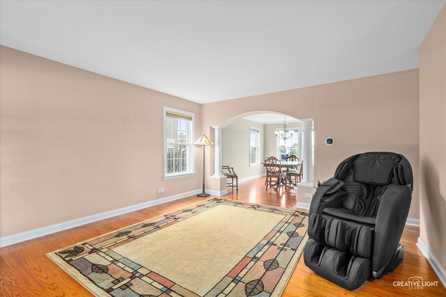 431 Blue Ridge Ct, Oswego, IL 60543 - sitting room featuring decorative columns, arched walkways, light wood-style floors, and a chandelier