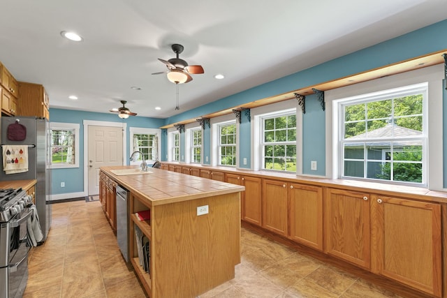 1046 N Riverside Dr, Momence, IL 60954 - kitchen with tile countertops, appliances with stainless steel finishes, ceiling fan, recessed lighting, and a center island