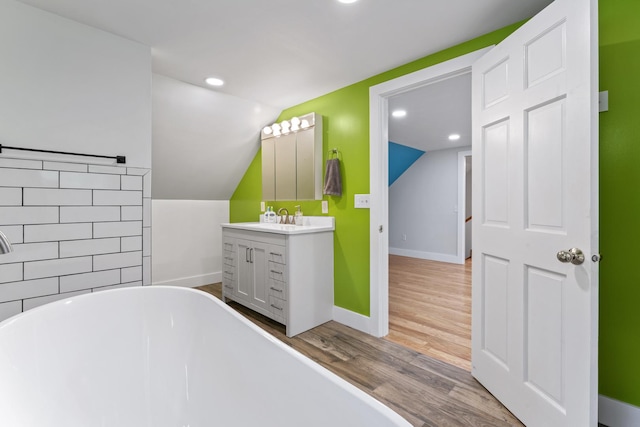 1046 N Riverside Dr, Momence, IL 60954 - full bath with a soaking tub, vanity, vaulted ceiling, wood finished floors, and recessed lighting