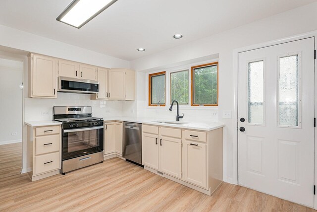 1500 Bunescu Ln, Buffalo Grove, IL 60089 - kitchen with appliances with stainless steel finishes, a sink, light wood-style floors, light countertops, and tasteful backsplash