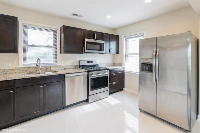 1678 Pratt Ave, Des Plaines, IL 60018 - kitchen with stainless steel appliances, a sink, light stone counters, dark brown cabinetry, and recessed lighting