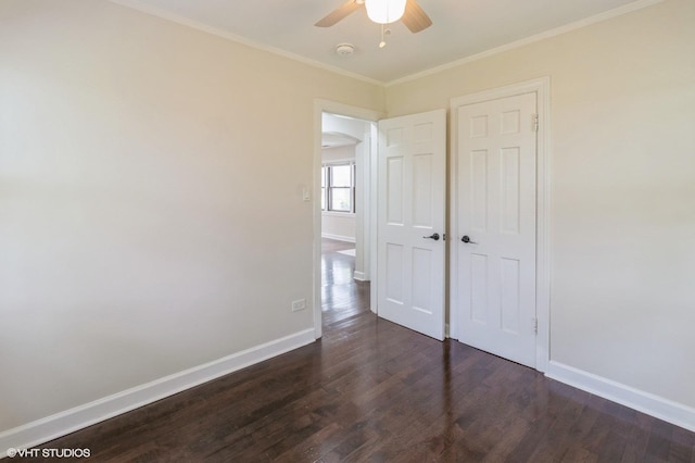 1678 Pratt Ave, Des Plaines, IL 60018 - unfurnished bedroom featuring dark wood-style floors, baseboards, crown molding, arched walkways, and ceiling fan