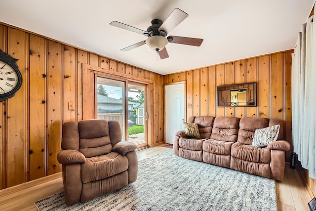 9001 Mobile Ave, Oak Lawn, IL 60453 - living room featuring a ceiling fan, wood walls, and light wood-style floors