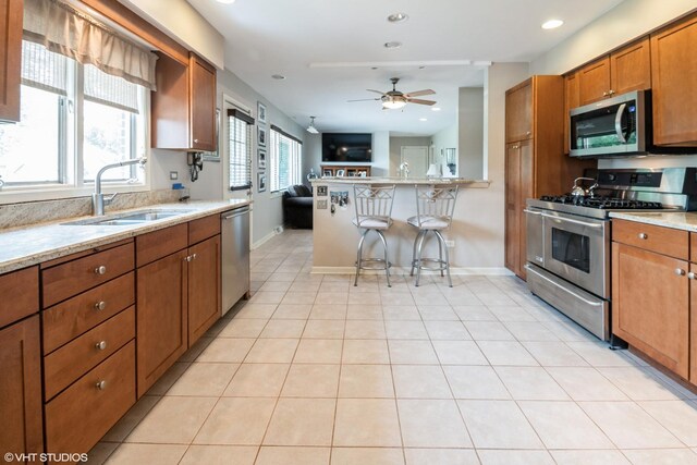 10901 W 131st St, Orland Park, IL 60467 - kitchen featuring appliances with stainless steel finishes, open floor plan, brown cabinets, ceiling fan, and a peninsula