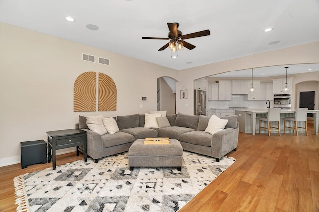 20111 N Woodland Cir, Mokena, IL 60448 - living area with arched walkways, light wood-style flooring, ceiling fan, and recessed lighting