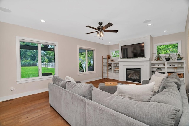 20111 N Woodland Cir, Mokena, IL 60448 - living area featuring a glass covered fireplace, light wood finished floors, ceiling fan, and recessed lighting